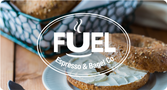 Fuel Espresso & Bagel Co. logo in front of a bagel with cream cheese